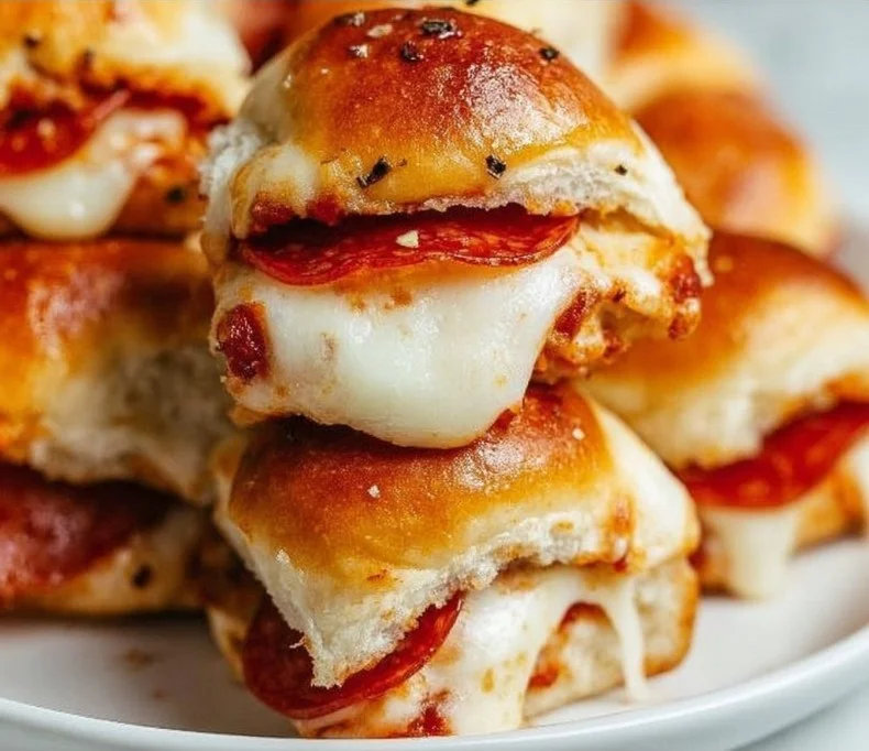 Pepperoni Pizza Sliders 3 Pepperoni pizza sliders served on a platter with melted cheese