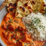 Delicious plate of butter chicken served with rice and naan bread