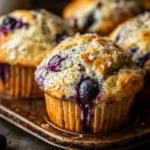 Blueberry lemon poppy seed muffins displayed on a rustic wood table.