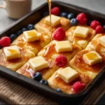 Delicious easy sheet pan pancakes served with syrup and berries