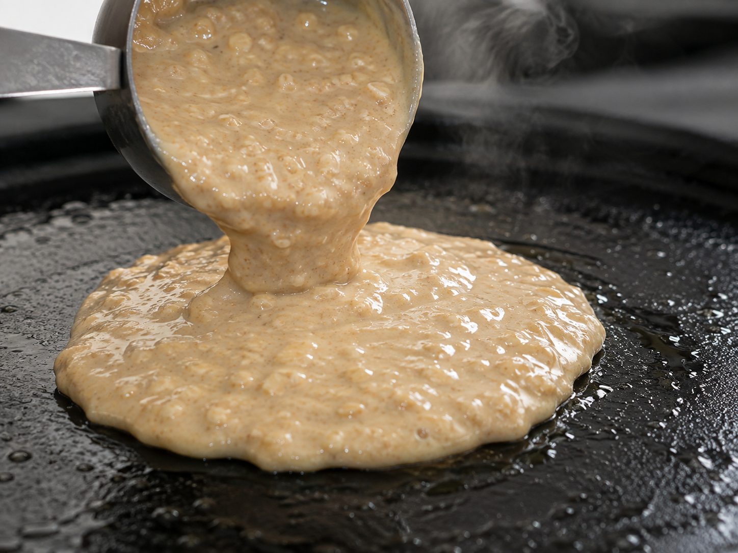 3-Ingredient Banana Oat Pancakes for a Fast, Flourless Breakfast 2 Banana oat pancake batter being poured onto a hot greased griddle