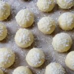 3-Ingredient Coconut Snowball Truffles coated in white chocolate and topped with shredded coconut