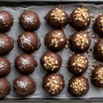Chocolate-dipped 3-Ingredient Mounds Bites arranged on waxed paper
