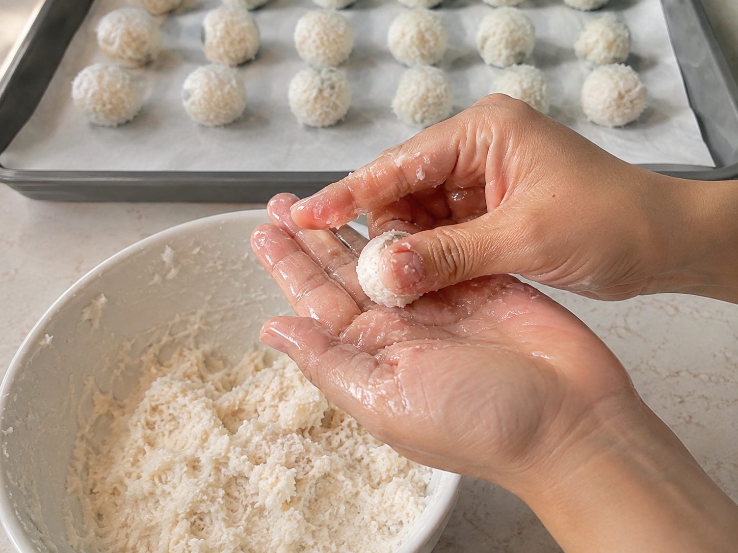 3-Ingredient Mounds Bites: No-Bake Coconut Candy You Roll and Dip 2 Hands rolling chilled coconut dough into a small ball for 3-Ingredient Mounds Bites